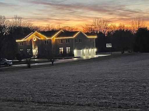 Roofline Christmas lighting installed on a home at night